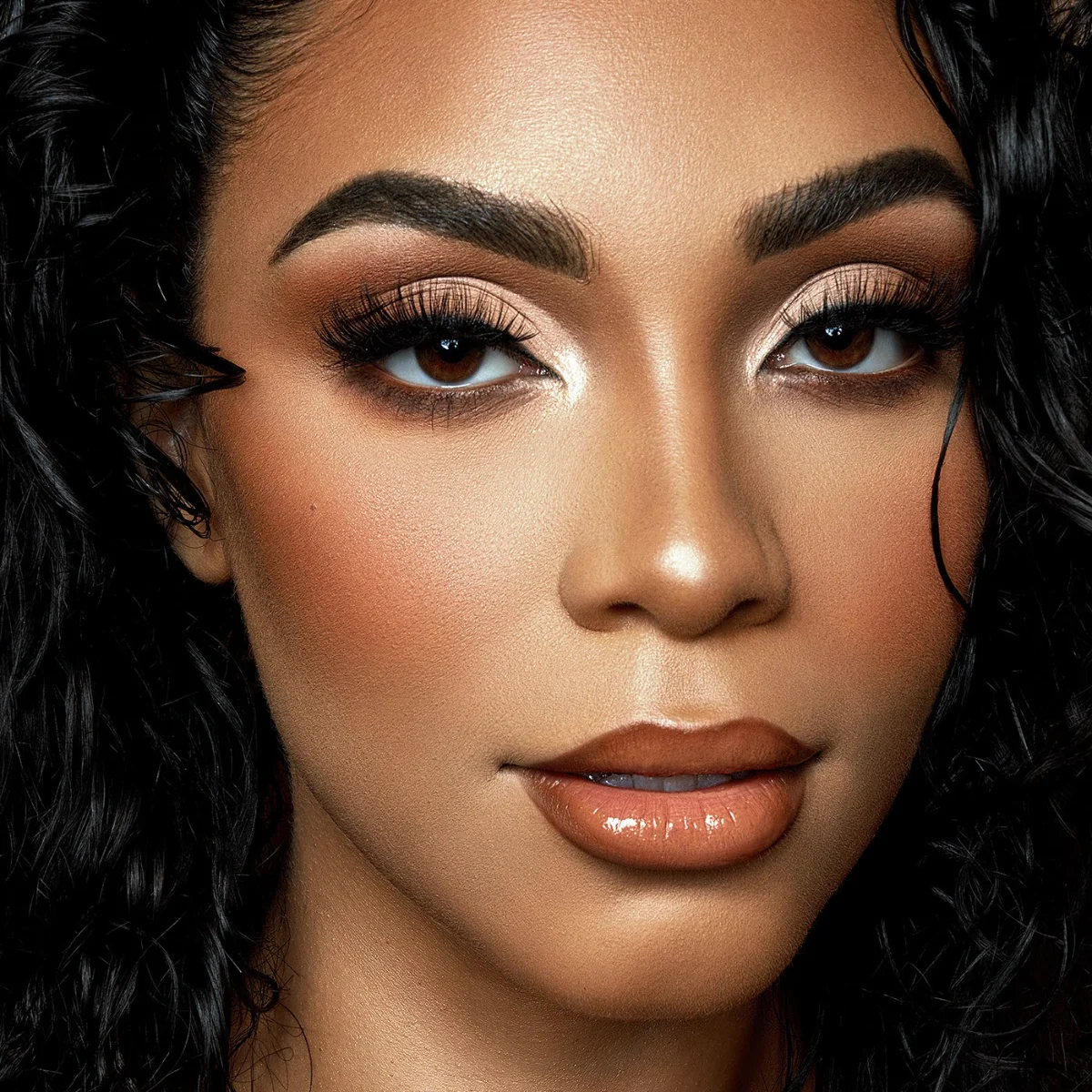 Close-up beauty portrait retouching of a model with wet-look curly hair and golden-bronze makeup