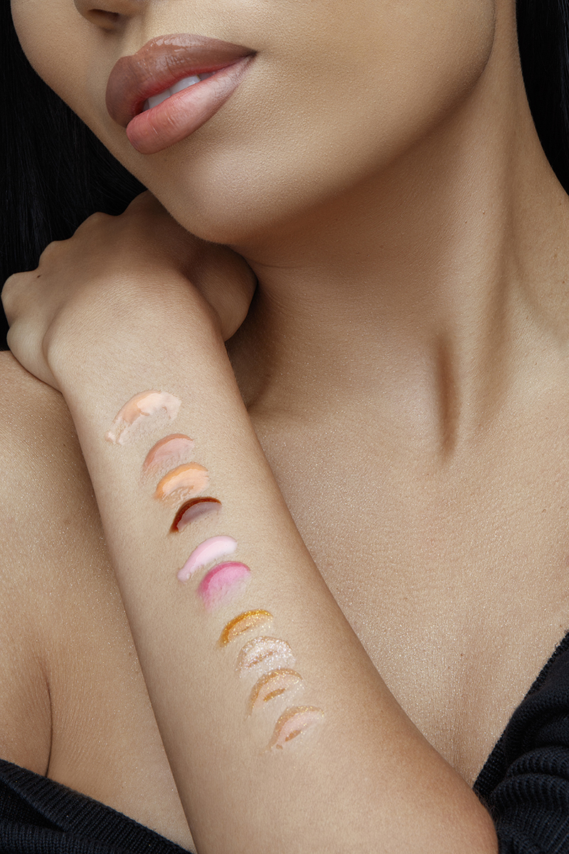 Cosmetics commercial portrait retouching showing a close-up of a model's arm with glossy and shimmery makeup swatches