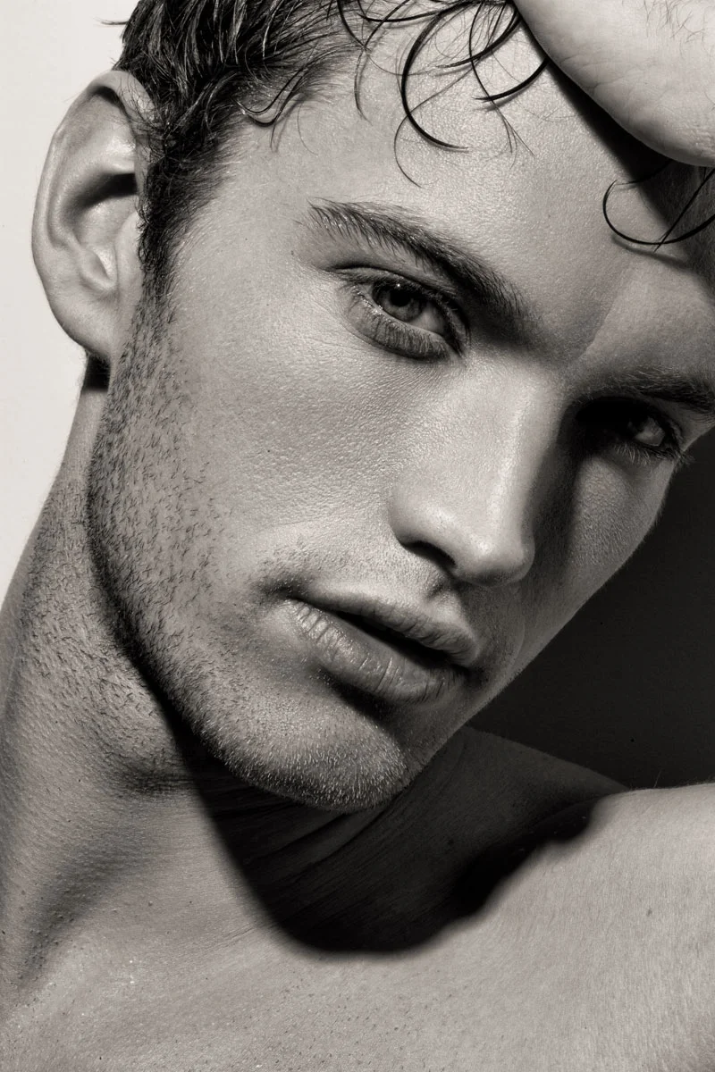 High-end close-up commercial portrait retouching of a male model with detailed skin and stubble correction