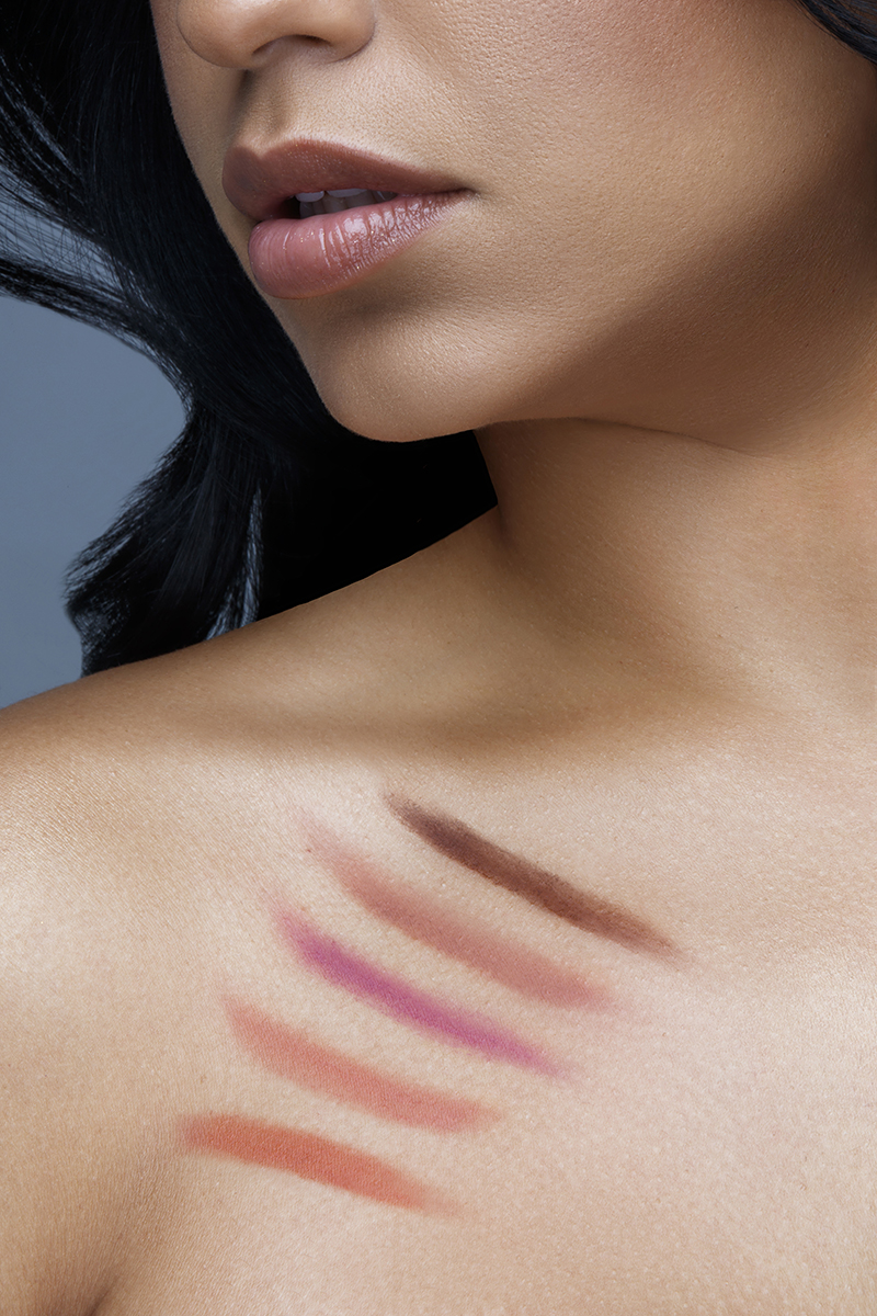 Cosmetics commercial portrait retouching showing a close-up of a model with matte foundation swatches on her chest and collarbone