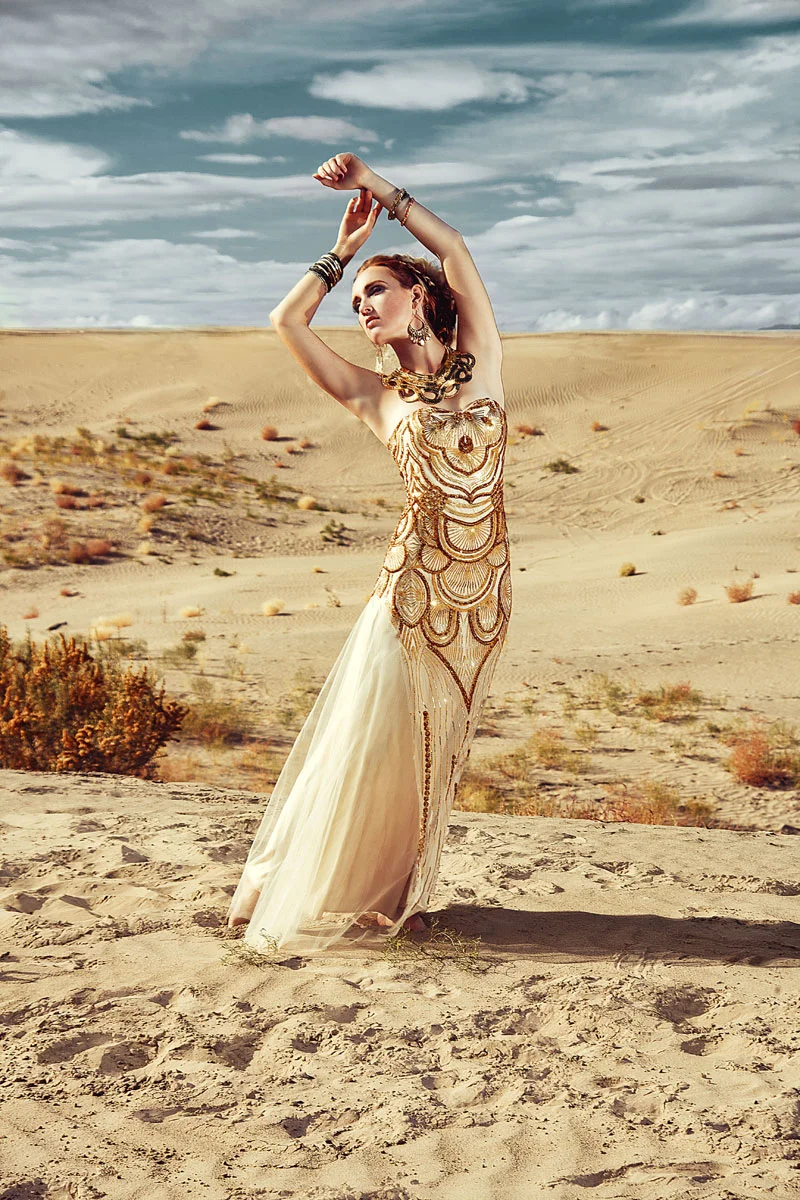 High-end fashion editorial retouching showing a model in an elegant gold sequin dress posing in a desert landscape