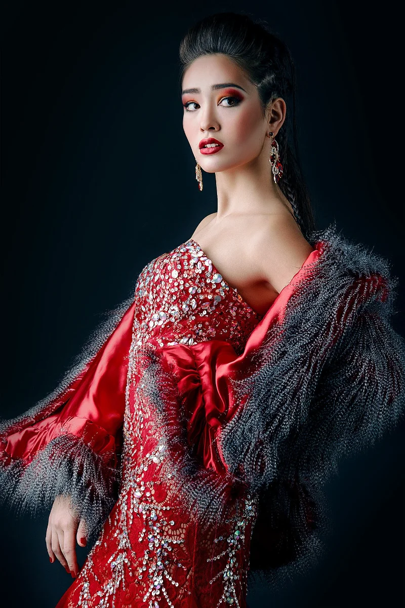Editorial fashion campaign retouching showing an Asian model in a red sequin evening gown with grey feather details